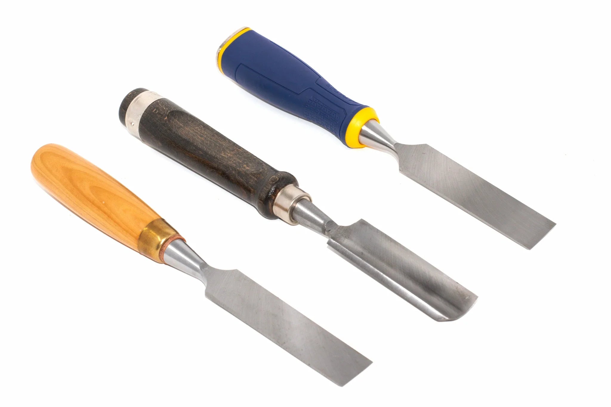 three types of chisels chisels laid side by side diagonally on a white background