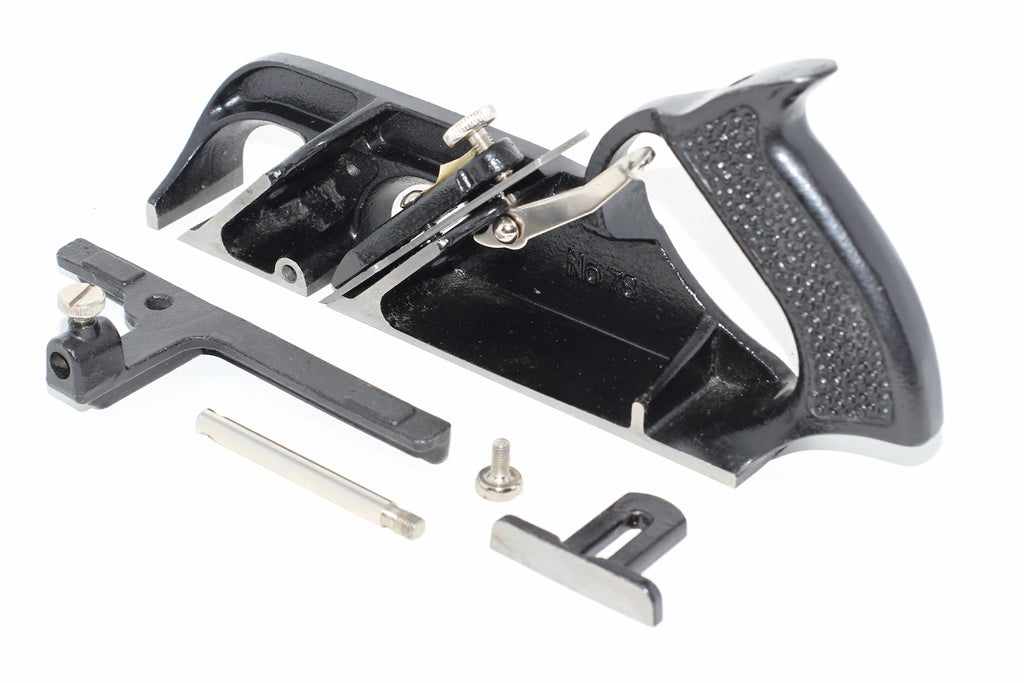 Stanley Duplex Rebate Plane No 078 shown with several small metal adjustment parts arranged beside it on a plain white background.