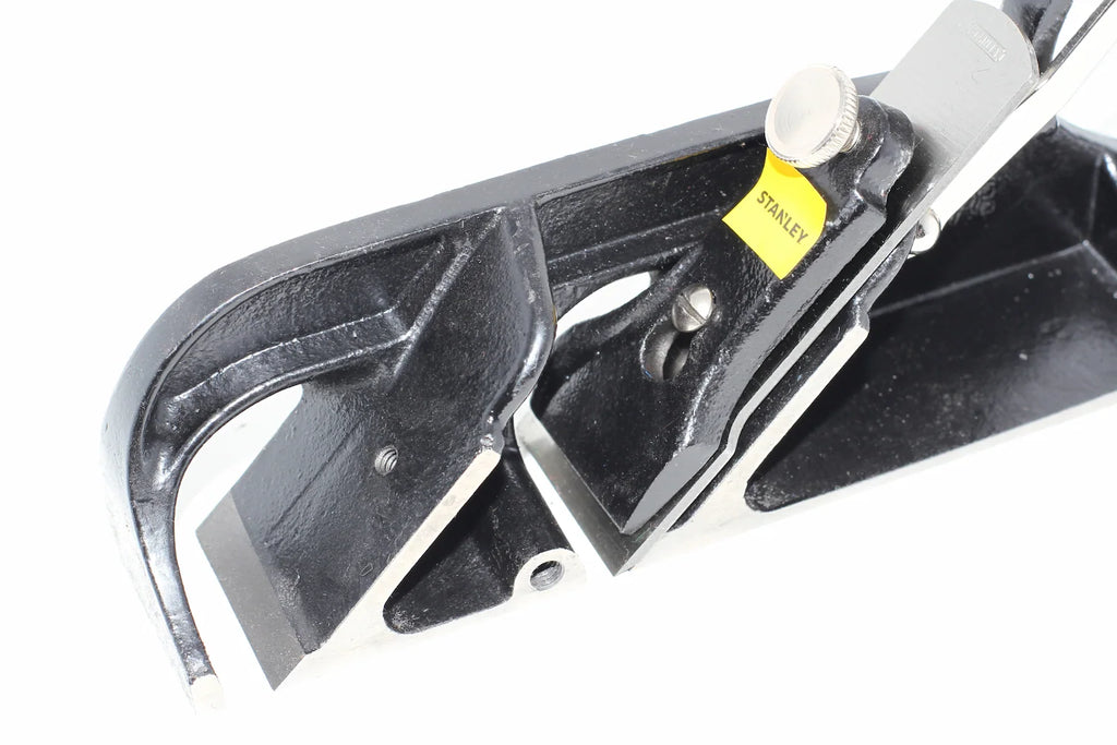 Stanley Duplex Rebate Plane No 078 Close-up of a black metal Stanley tool with a small yellow Stanley label, photographed on a white background.