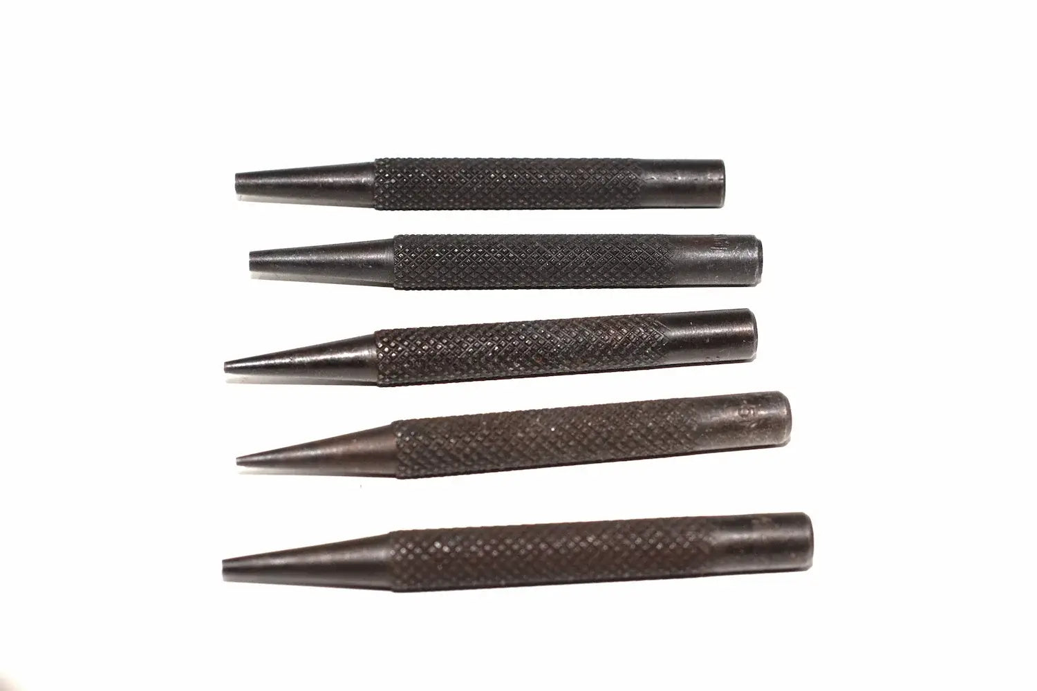 Silverline 5pc nail punch set Five dark metal punch tools with textured knurled handles, arranged vertically on a plain white background.