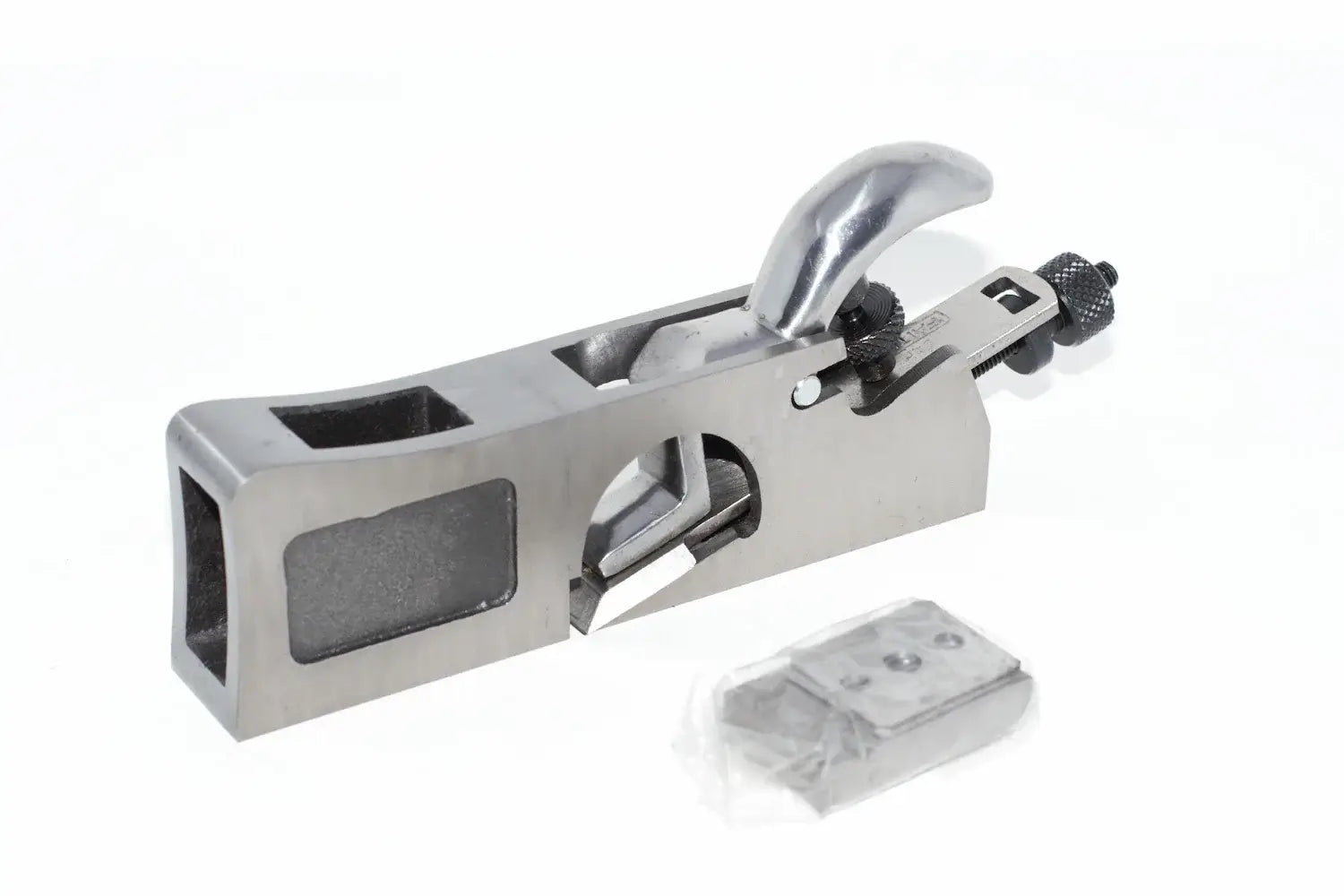 A faithfull 3 in 1 Shoulder Plane 27mm with a polished metallic finish and a small plastic-wrapped accessory piece placed below it, photographed on a clean white background.